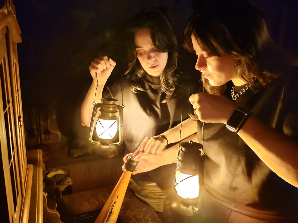 Escape room Migas de Pan Marbella — dos jugadoras explorando con faroles